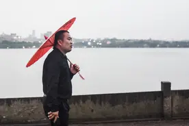 杭州暴雨下实拍西湖 男子撑油纸伞 小伙背美女在断桥飞奔图片