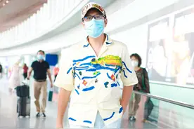 蔡国庆米色印花衬衫搭配蓝色休闲裤，不畏年龄机场放飞自我跳起来图片