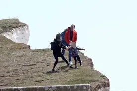 英国小女孩百多米高悬崖边上好奇探头，旁边没护栏，幸被及时拉住图片