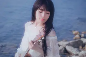在海边弹尤克里里的少女图片