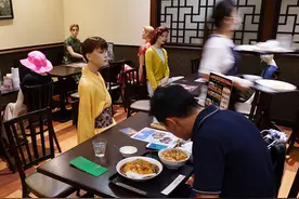 日本餐厅摆放十几个假人模特陪顾客吃饭，顾客少，用它来凑有创意图片