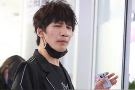 大张伟现身机场，一袭黑色还有爆炸头，眯着眼睛是表情帝图片