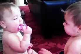 为一个奶嘴，双胞胎宝宝展开抢夺之战，可爱又逗趣的模样让人萌翻图片