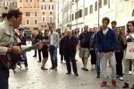 街头音乐家在罗马街头电吉他演奏，路人纷纷驻足围观