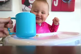 妈妈用杯子给宝宝喝水，宝宝高兴的模样真招人喜欢啊！