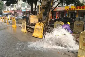 挖掘机啃爆水管路面冒出喷泉 维修人员带水作业图片