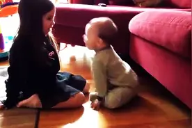 妈妈想拍下孩子们的可爱互动，结果小婴儿展开双手做的事让人融化图片