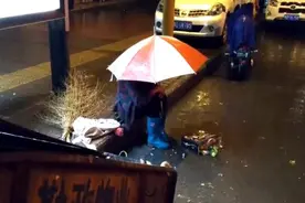 暖炸！平顶山老太雨中撑伞犯困，坐地等环卫老伴下班图片