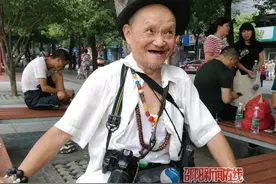 邵阳八旬老人身上挂五个相机 随时记录身边风景和人物图片