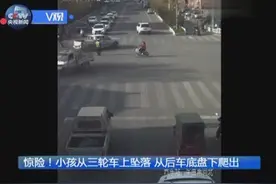 惊险！小孩从三轮车坠落卷进后车底盘 滚滚车流中惊险爬出图片