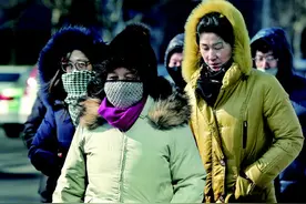 冻透了！青岛持续低温 街头行人戴帽抵挡寒风图片