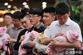 哈尔滨青年抱娃娃“喂奶”庆母亲节图片