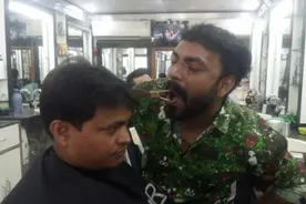 印度理发师嘴叼剪刀为客人理发走红网络图片