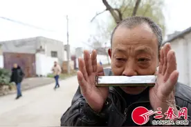 六旬男子可单手夹起5块砖 用鼻子吹口琴图片