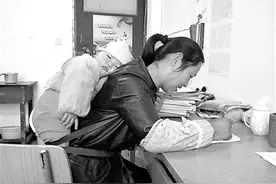 背着孩子改作业的女教师图片