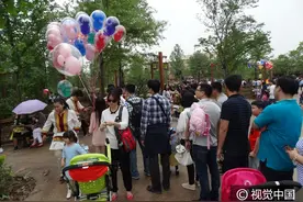 上海迪士尼园各景点人气旺，“米奇气球”受欢迎游客排长队购买图片