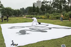 书法家雷宪和汨罗江畔泼墨挥毫 巨型“龙”字一气呵成图片