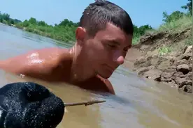 咱们到河里摸小鱼小虾，看这个男子在河里徒手抓到好大一条鱼图片