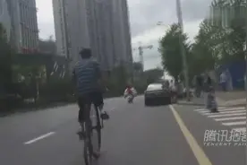 男子骑100年前自行车过街 引路人围观图片