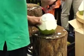 街头小贩展示砍椰子神技，椰子皮削得一干二净，肉和汁完好无损！图片