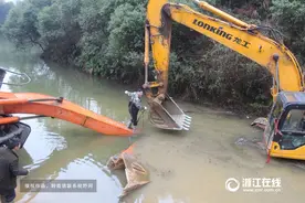 江山一挖掘机翻入鱼塘 驾驶员被困动弹不得 (图片