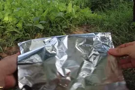 小伙在折叠一张锡箔纸，几分钟后他就吃上了美味的水煮鸡蛋图片