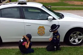 一双儿女跪在警车边，为爸爸祈祷，“我们只想要你平安地回来”图片