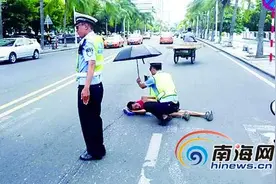 三亚街头现暖心一幕 交警借伞为晕倒男子遮阳图片