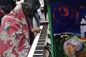 实拍：一个无家可归的流浪汉弹奏悲伤的钢琴曲，路人纷纷驻足聆听图片