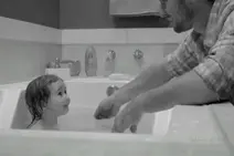 爸爸给小女儿洗澡，小女孩和爸爸的表情都萌萌的图片