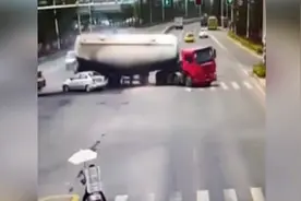在路口，水泥罐车先撞小货车，翻车后将等信号的轿车压扁！图片