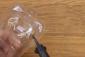 在塑料瓶底戳出几个洞，放在花园变成实用的洒水器图片