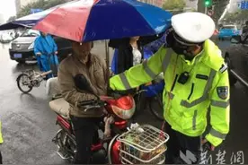 武汉交警雨中拆除电动车顶篷576个 耐心劝导赠送雨衣图片