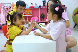 两个小萝莉比赛扳手腕，拉汽车，看谁获胜，就奖励棒棒糖