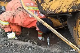 挖掘机施工时侧翻，消防员徒手清理碎石救人图片
