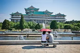 朝鲜的街头，新娘穿着艳丽的民族服装，很拘谨，羞涩的低头弄衣角图片
