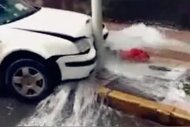 轿车失控撞上消防栓 水流漫延到路面上图片