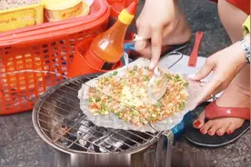 泰国街头奇特的小吃，饼直接放在炭火上烤，看着很不错！