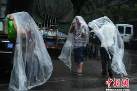 重庆主城突降暴雨 街头民众自制雨衣避雨图片