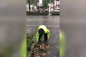 台风天树叶堵塞排水，交警涉水徒手清理