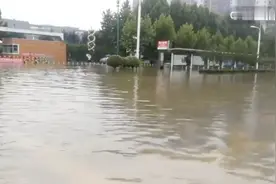 河南商丘连日大雨淹没道路，站台被水淹没，路人淌水走路