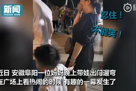 男孩专心看热闹牵错手，陌生阿姨故意不提醒，一手捂住嘴努力憋笑图片
