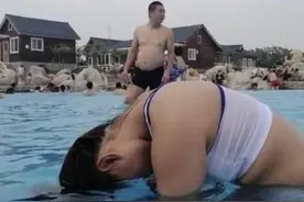 女子模仿网红水中甩头发，结果用力过猛，一旁大叔目睹尴尬画面图片