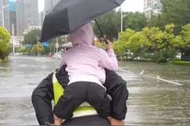 车辆熄火“趴窝”交警背孩子淌水走过一个路口图片