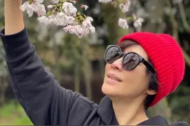 55岁刘嘉玲素颜赏樱，穿卡通卫衣配健美裤，戴红帽拍游客嗅花照图片