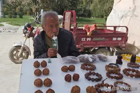 75岁大叔在景区门口摆摊，回家需要两小时，中午带一包奶顶午饭图片