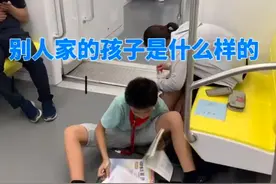 广西一男孩地铁上旁若无人席地写作业，丝毫不受人来人往的影响图片