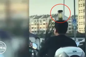 马路上练杂技？男子头顶茶杯骑车，自称为了治病图片