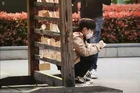张艺兴路透照曝光 蹲地上写许愿牌祈福平安图片