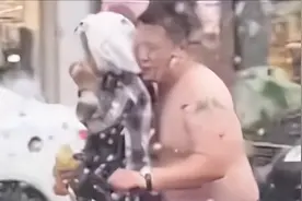 河北一男子在雨中光膀子骑行，上衣为儿子挡雨，网友：这就是父爱图片